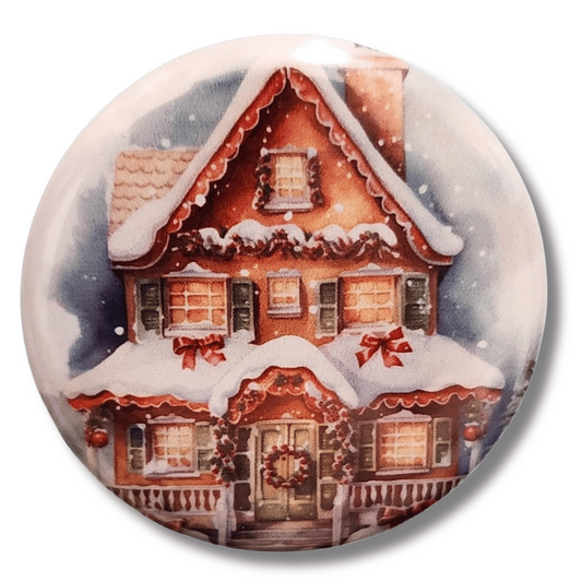 Snow-covered gingerbread house magnetic needle minder with glowing windows and festive red bows