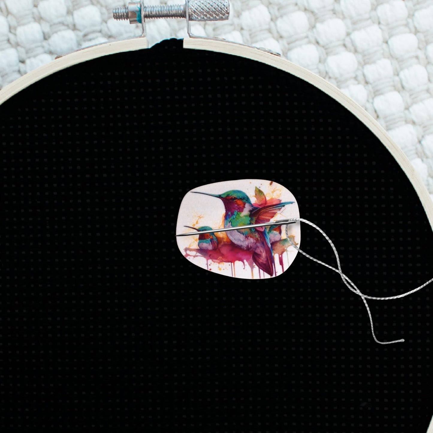 Nature-inspired magnetic needle minder showcasing three colorful hummingbirds in a painterly splash background.