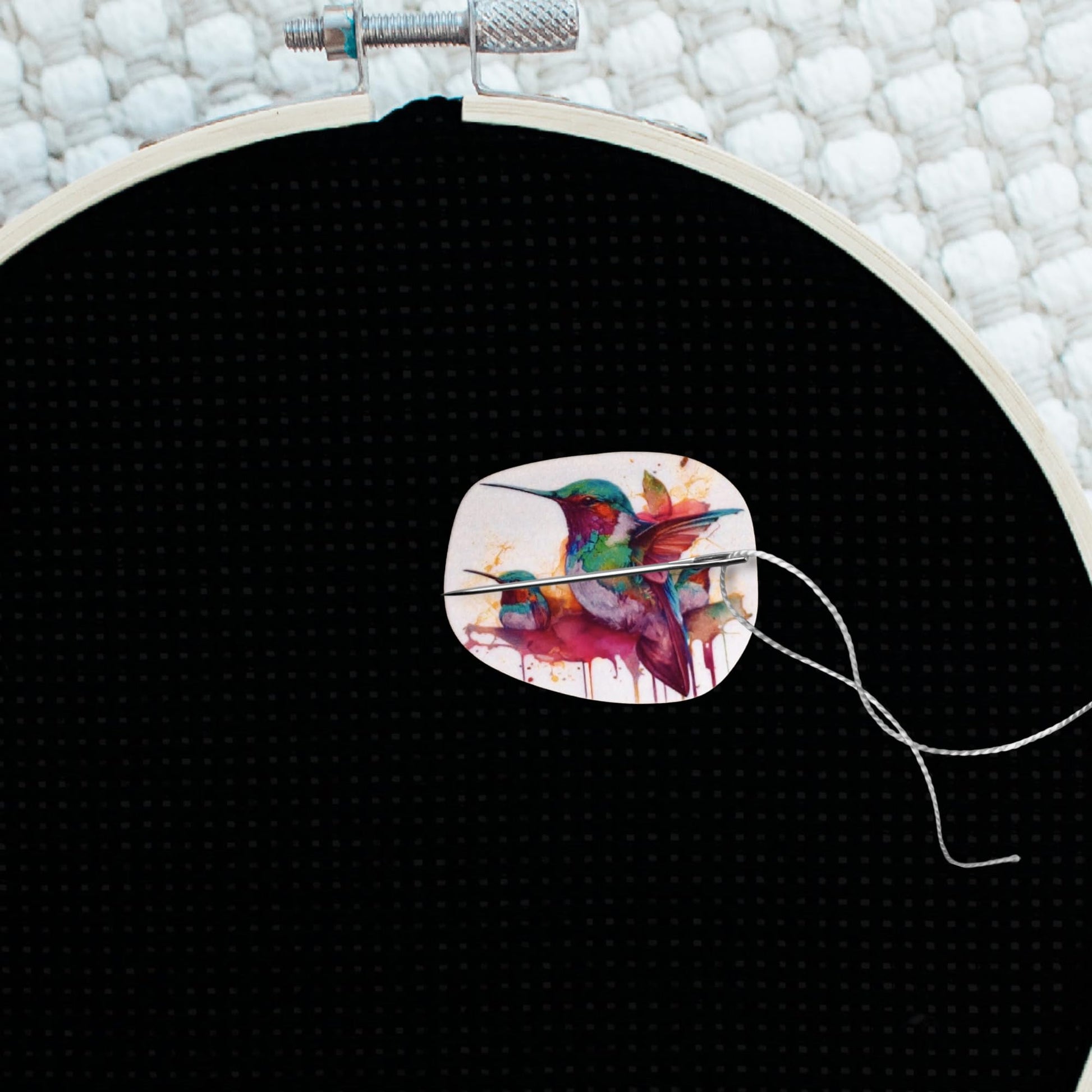Nature-inspired magnetic needle minder showcasing three colorful hummingbirds in a painterly splash background.
